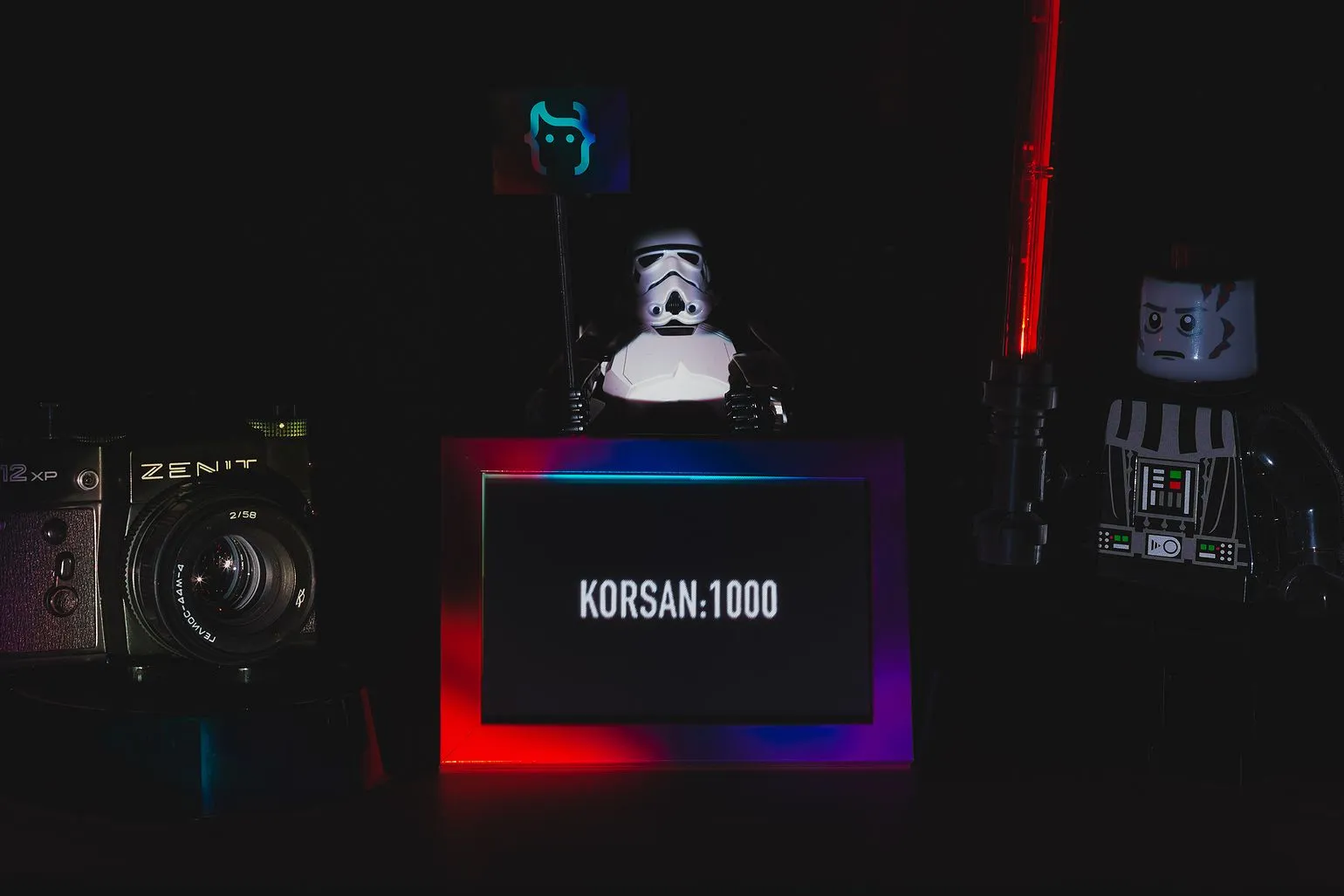 LEGO Star Wars figures, a stormtrooper and Darth Vader with a lightsaber, next to a Zenit camera and a glowing sign reading KORSAN:1000