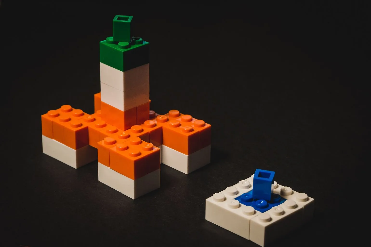 Białystok City Hall built from a dozen orange, white and green LEGO bricks on a dark background