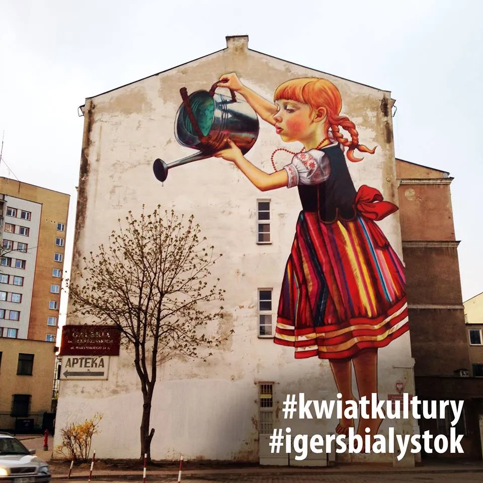 Natalia Rak's mural of a girl watering a bare tree from a watering can, with the hashtags #kwiatkultury and #igersbialystok