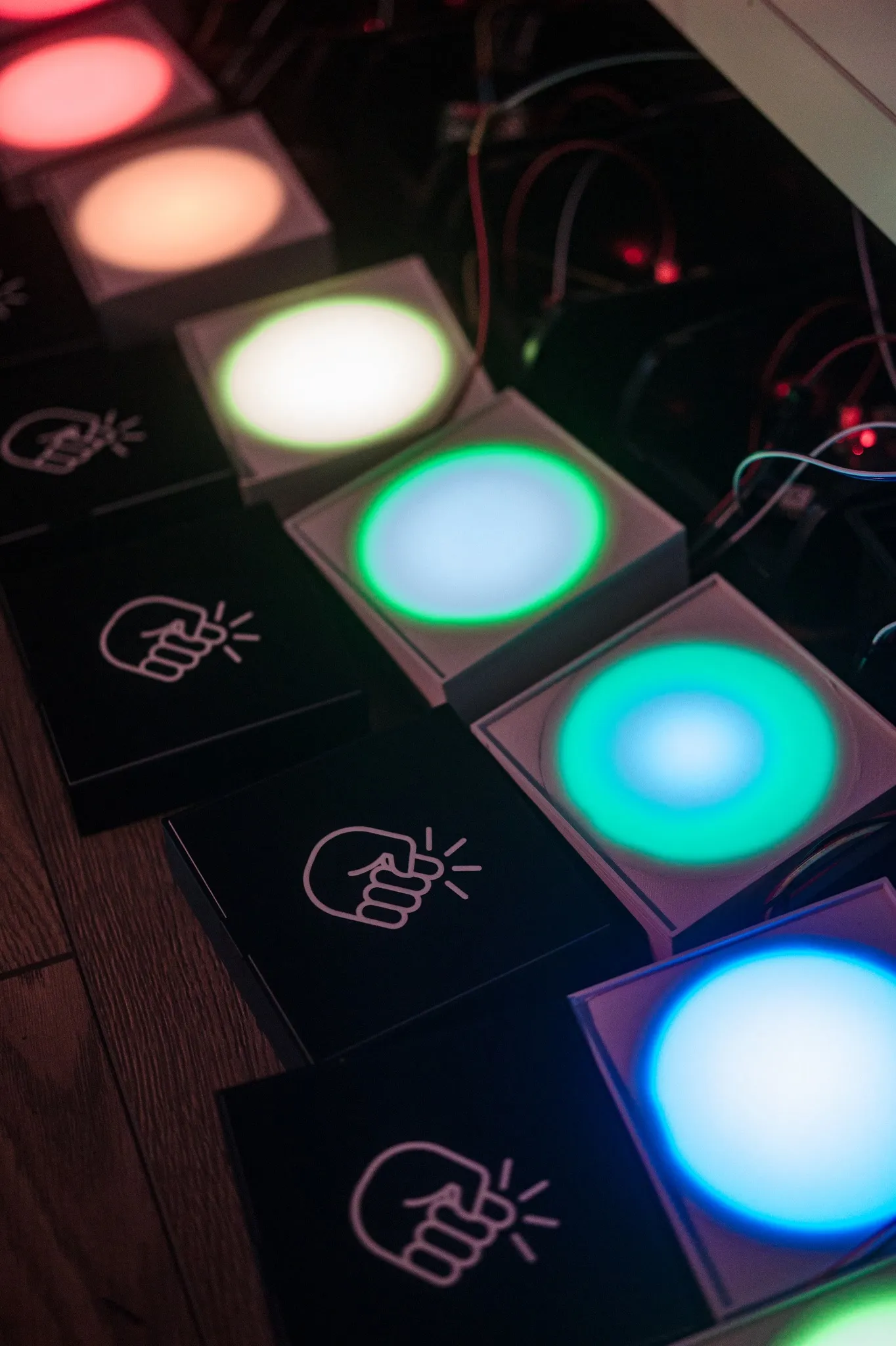 A row of lit light modules in different colours next to black plates with a knock pictogram