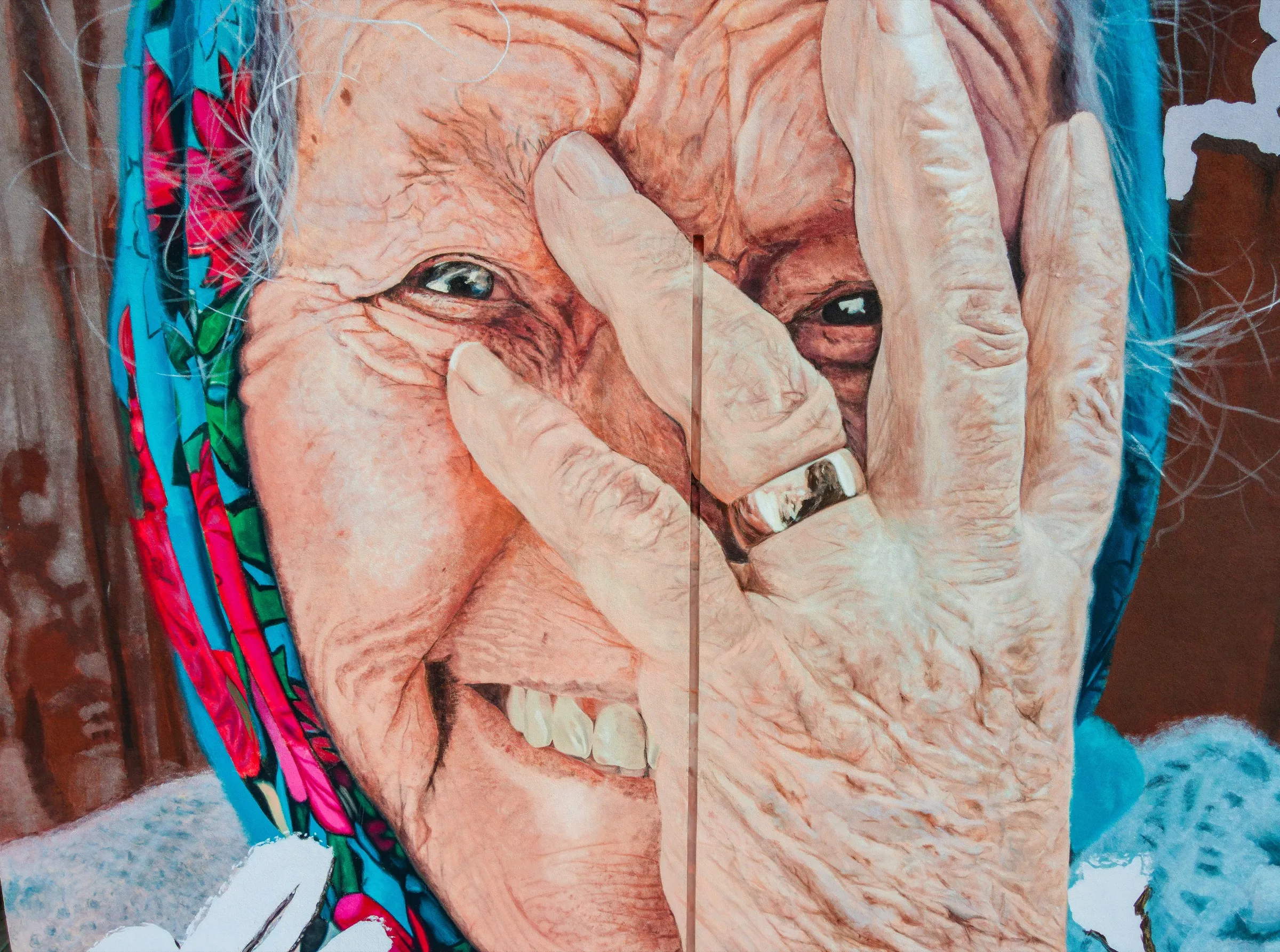 Close-up of the mural: a smiling elderly woman in a colourful headscarf covers part of her face with a hand wearing a wedding ring