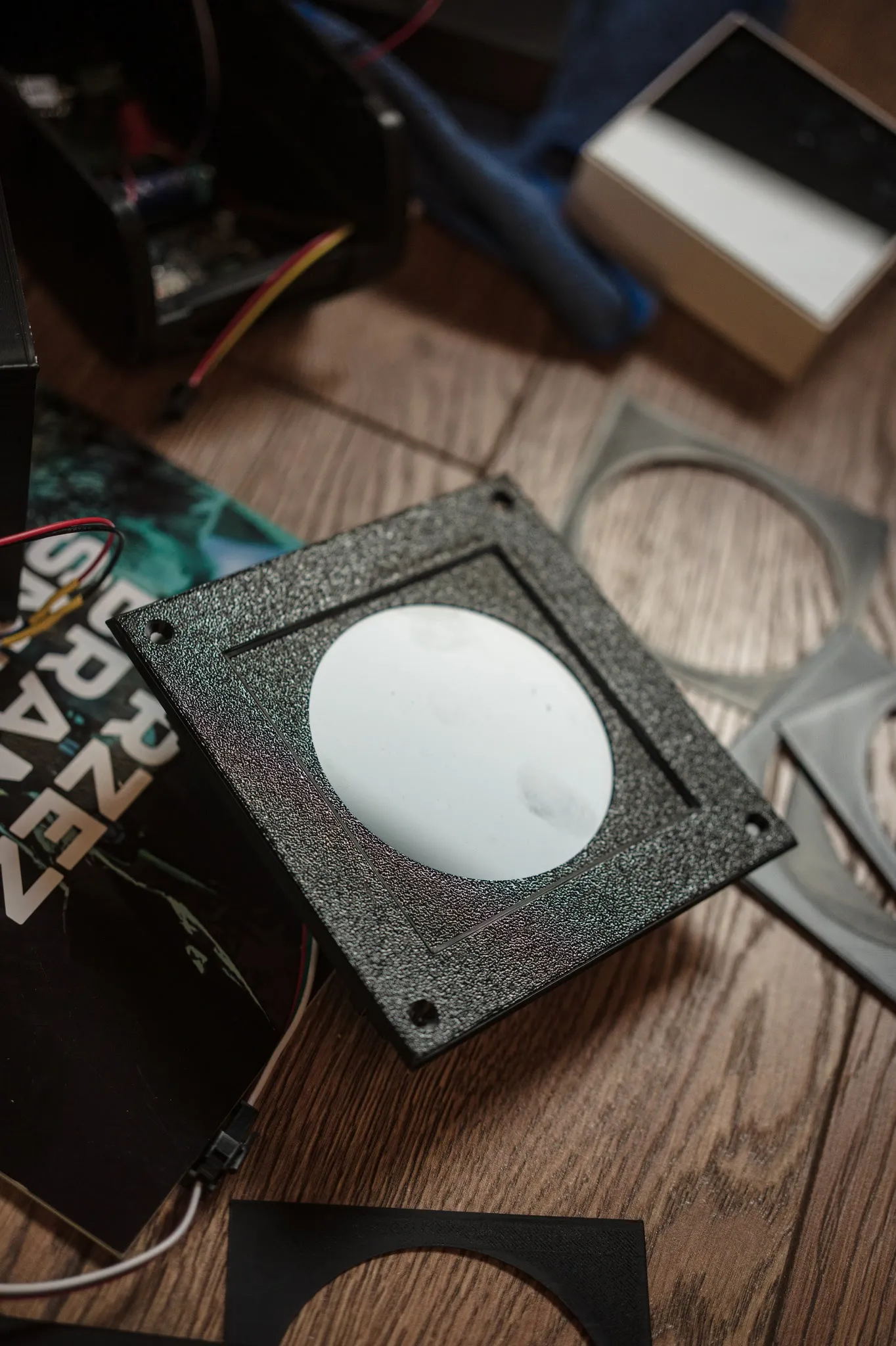 A black 3D-printed panel with a round milky light diffuser