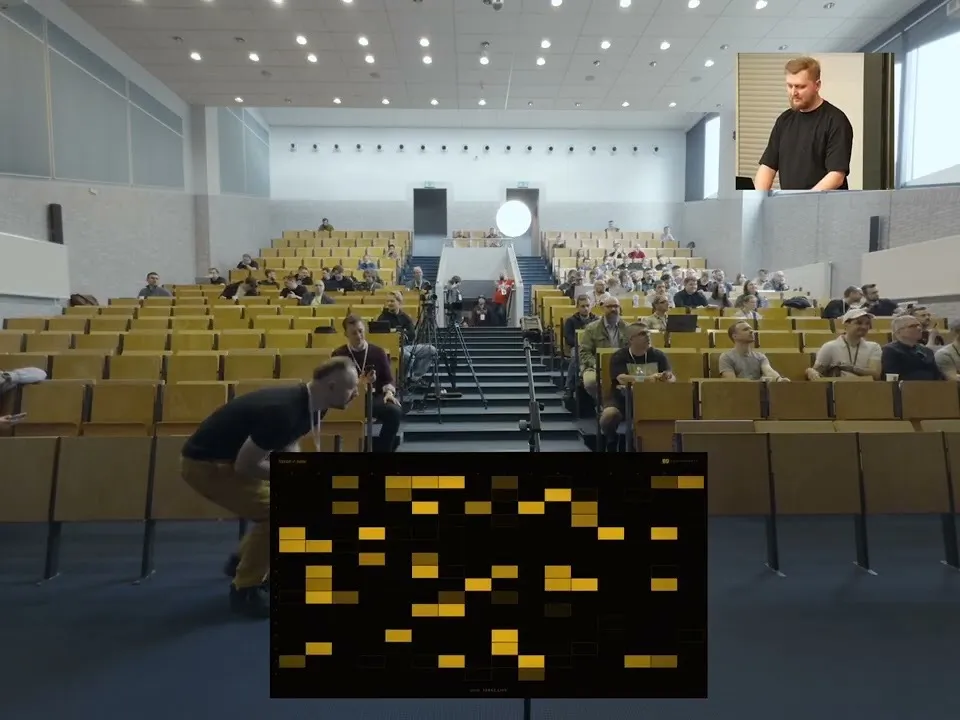 Lecture hall at wroclove.rb 2026: the audience holding their phones, with a screen in front showing a grid of yellow rectangles, one per participant